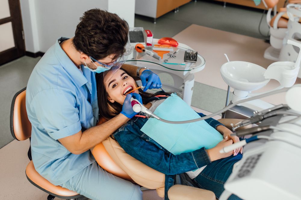 a woman is getting dental treatment.